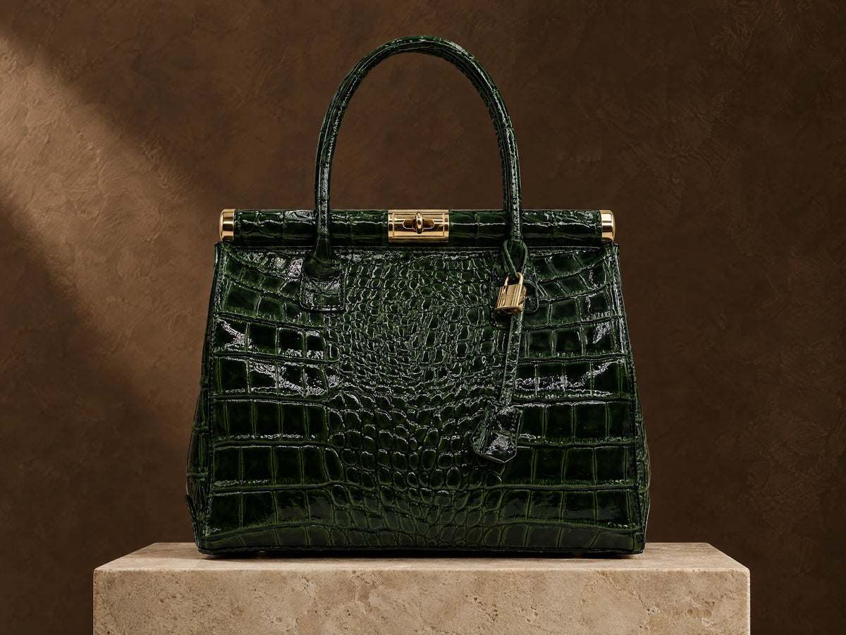 Brown leather handbag on travertine beside softly folded leather